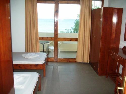 a room with two beds and a view of the ocean at Kato Stalos Beach in Stalos