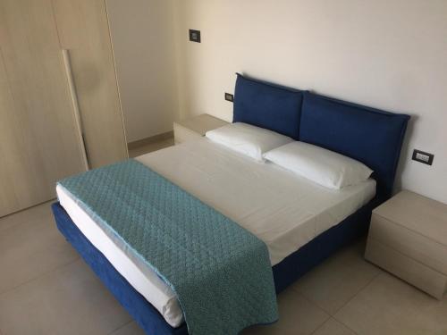 Un dormitorio con una cama con cabecero azul. en Attico La Pergola, en Moniga del Garda