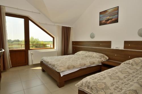 a hotel room with two beds and a window at Vila Maria Snagov in Snagov