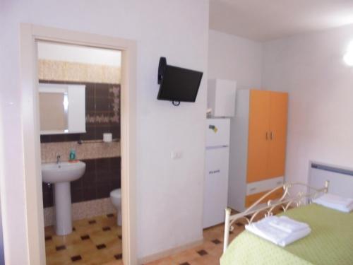 ein Bad mit einem Waschbecken und einem WC sowie einen TV in der Unterkunft Le Turciane Casavacanze in Castro di Lecce