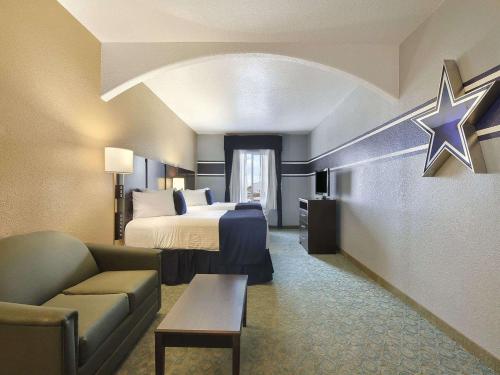 a hotel room with a bed and a couch at Ramada by Wyndham South Waco in Hewitt