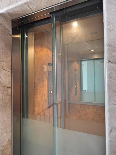 a glass door of a building with a mirror at Appartamenti al Golfo in Salò