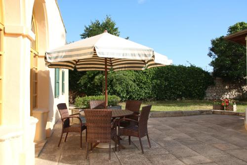 einen Tisch und Stühle mit Sonnenschirm auf einer Terrasse in der Unterkunft Hotel Rural Son Tretze - Adults Only in Sant Lluís