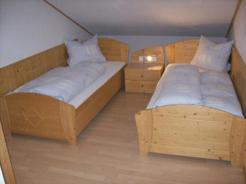 two twin beds in a room with wooden floors at Haus Gartenheim in Kals am Großglockner