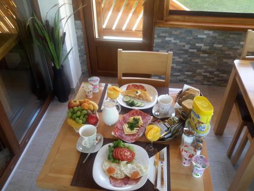 ein Holztisch mit Tellern voller Essen darauf in der Unterkunft Lake House in Jezerce