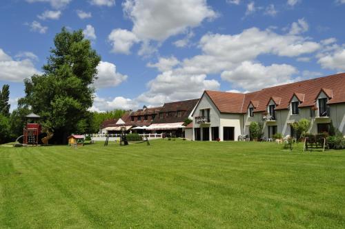 
a large house with a large yard and trees at Logis Le Relais De Pouilly in Pouilly-sur-Loire
