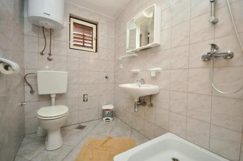 łazienka z toaletą i umywalką w obiekcie Apartments Renato w Novalji