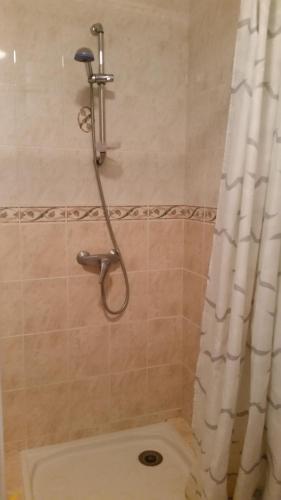 une douche avec un rideau de douche dans une salle de bain dans l'établissement Studio Ebeyer, à Saint-Laurent-de-la-Cabrerisse