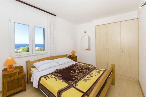 a bedroom with a bed and two windows at House Marija in Primošten