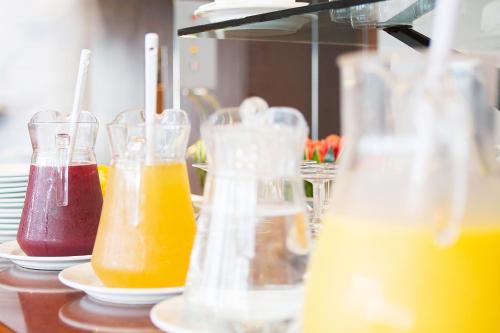 a row of glass vases filled with different colored liquids at Hotel 3K Madrid in Lisbon