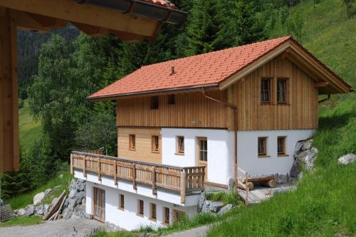 a house with a wooden roof on a hill at Lechtaler Naturparkchalets in Gramais