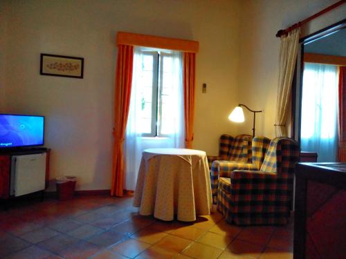 ein Wohnzimmer mit einem Tisch und einem TV in der Unterkunft Hotel Rural Son Tretze - Adults Only in Sant Lluís