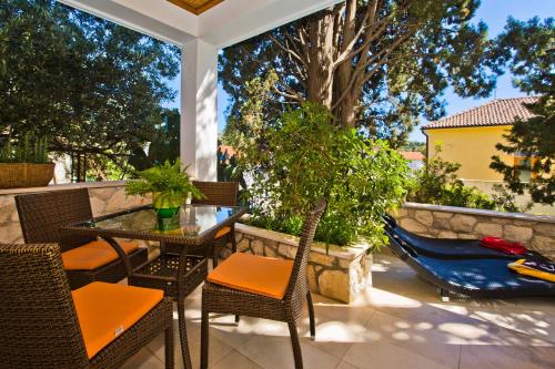 a patio with a table and chairs and a hammock at Castle Štambuk in Hvar