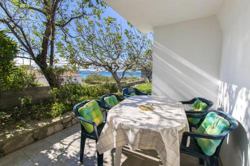 a table and chairs on a patio with a view of the ocean at Apartments Milena in Rtina
