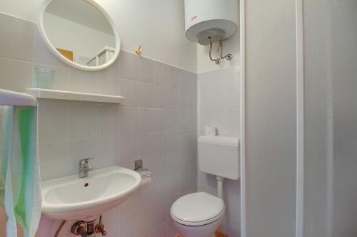 a bathroom with a toilet and a sink and a mirror at Room Milka in Veli Lošinj