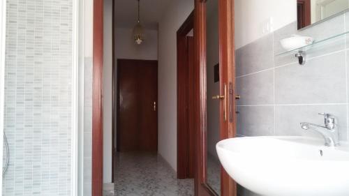 uma casa de banho com um lavatório branco e um corredor em Le Bolle em Maranello