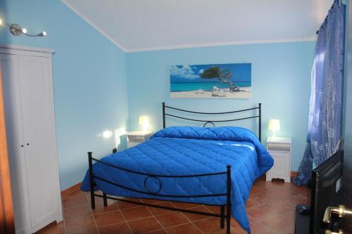 a blue bedroom with a bed with a blue comforter at Il sottosopra in Labico