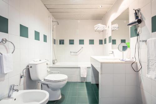 La salle de bains blanche est pourvue de toilettes et d'un lavabo. dans l'établissement Hotel 3K Madrid, à Lisbonne