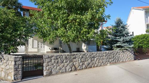 a stone retaining wall in front of a house at Apartmani Gaj in Malinska