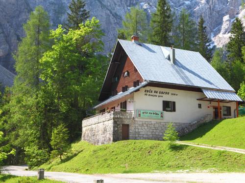 a building on top of a hill with trees at PLANINSKA KOČA NA GOZDU in Kranjska Gora