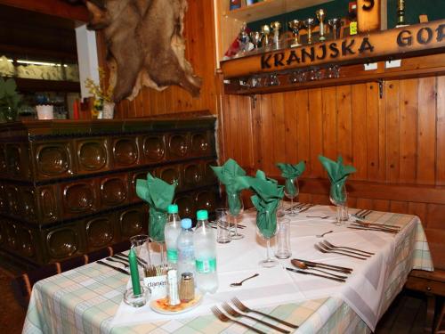 a table in a restaurant with a white table cloth at PLANINSKA KOČA NA GOZDU in Kranjska Gora