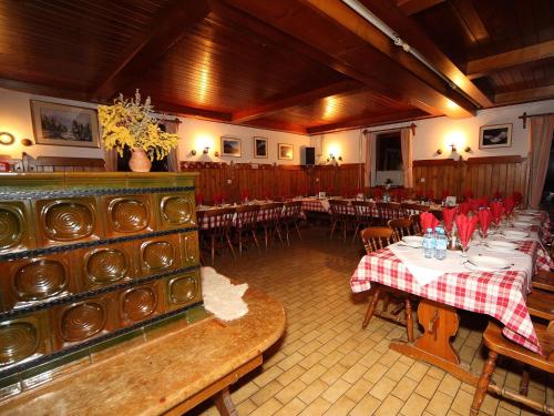 a dining room with tables and chairs in a building at PLANINSKA KOČA NA GOZDU in Kranjska Gora