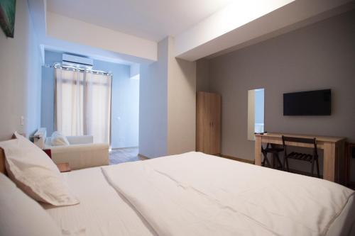 a bedroom with a bed and a desk and a television at Heights Accommodation in Bucharest