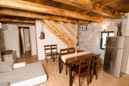 a kitchen and dining room with a table and a refrigerator at House Radojka in Tisno