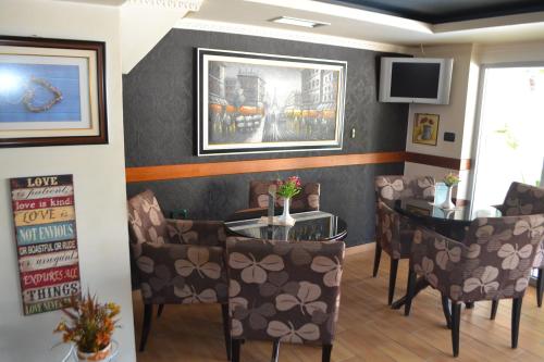 a dining room with a table and chairs and a tv at Funky Guest House & Adventures in Përmet