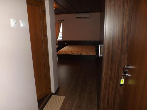a room with a bedroom with a bed and a door at Dragoevata Kashta in Kotel