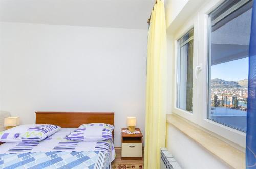 een slaapkamer met een bed en een groot raam bij Apartment Marijana in Trogir