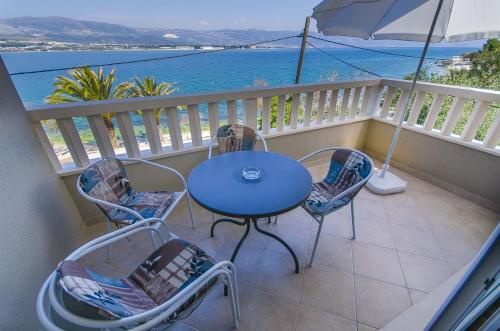 una mesa y sillas en un balcón con vistas al océano en Apartments Janja, en Trogir