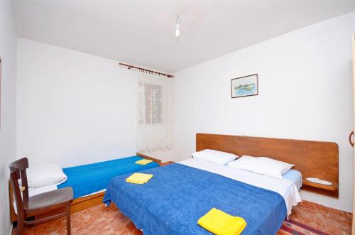 a bedroom with a blue bed and a chair at House Slavka in Gdinj