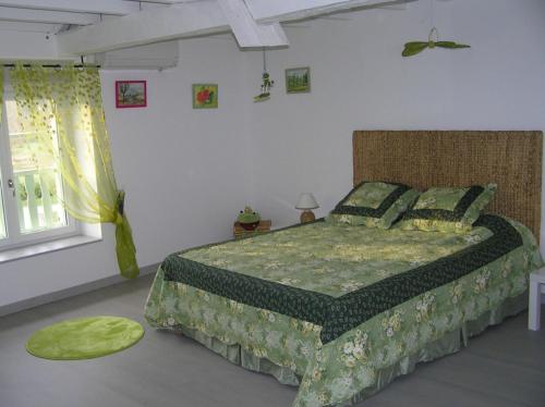 - une chambre avec un lit et une couette verte dans l'établissement Chambres d'hôtes Au Pére Louis, à Labastide-du-Vert
