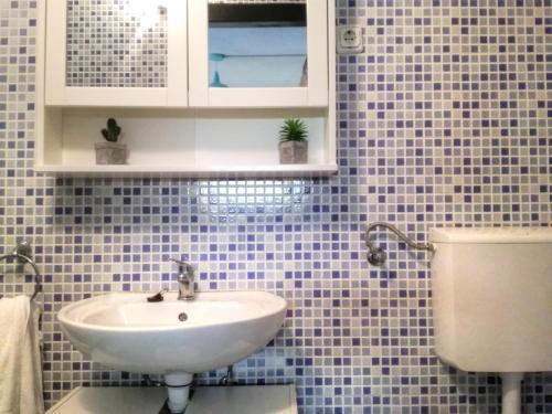 a blue tiled bathroom with a sink and a toilet at Holiday House Little Precious in Sveti Anton
