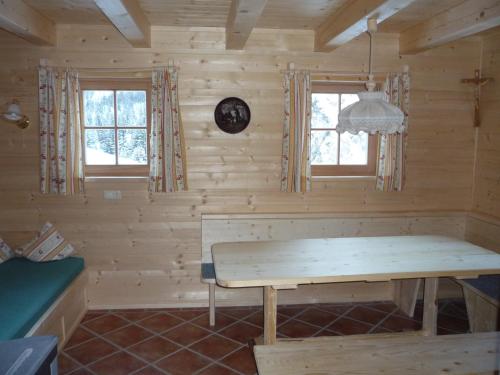 a log cabin with a wooden table and two windows at Lechtaler Naturparkchalets in Gramais