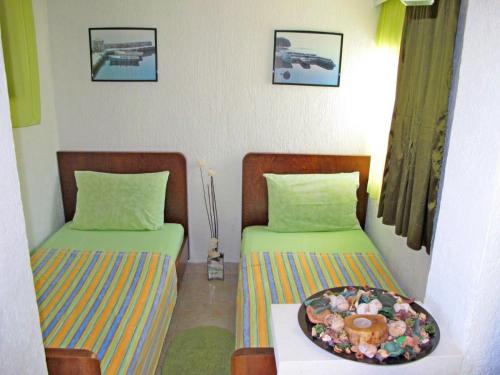 een kamer met twee bedden en een bord eten bij House Silvana in Postira