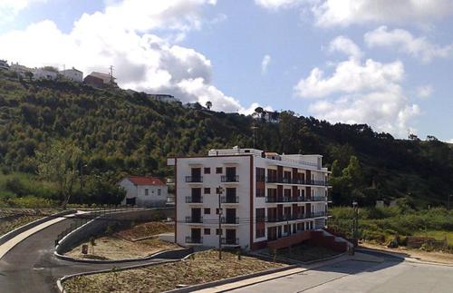 a white building on the side of a road at Nazaré T2 Vista Mar in Nazaré