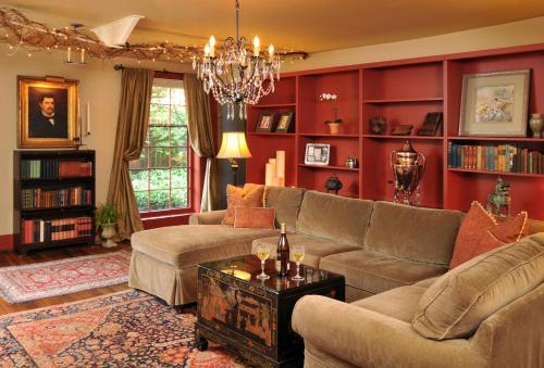 a living room with red walls and couches and a chandelier at 1795 Acorn Inn Bed and Breakfast in Canandaigua