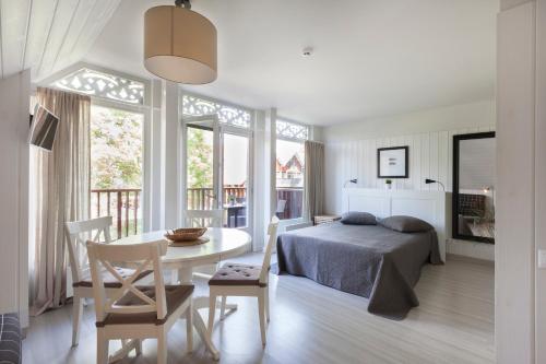 a bedroom with a bed and a table and chairs at Preilos vasara in Preila