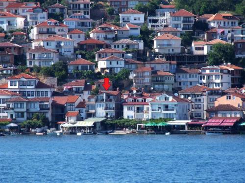 un groupe de maisons sur une colline à côté de l'eau dans l'établissement Orhidea House, à Ohrid