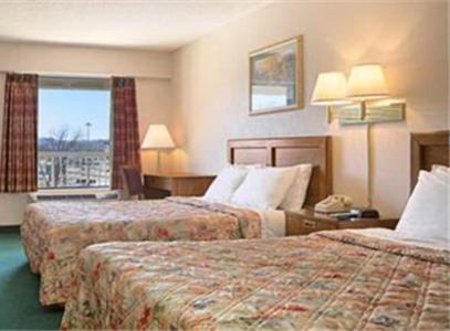 a hotel room with two beds and a window at Days Inn by Wyndham Apple Valley Pigeon Forge/Sevierville in Pigeon Forge