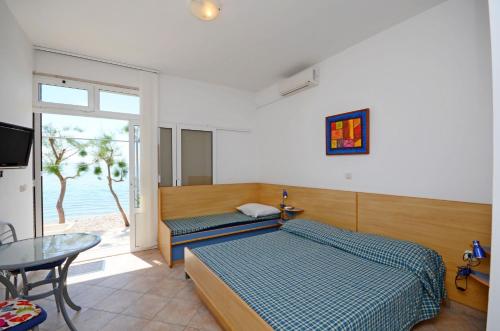 a bedroom with two beds and a table and a window at Apartments Jure in Drasnice