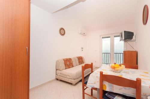 a living room with a table and a couch at Apartments Igor in Krvavica