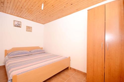 a bedroom with a bed and a wooden cabinet at House Krunoslav in Postira
