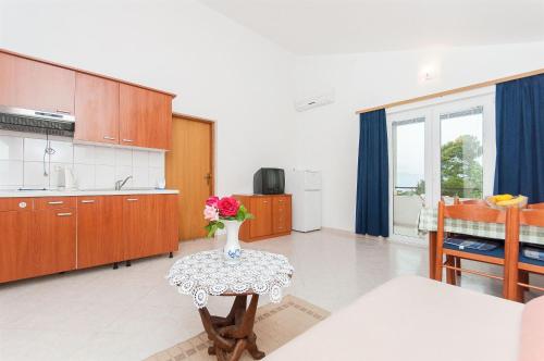 a kitchen with a table with a vase of flowers on it at Apartments Igor in Krvavica