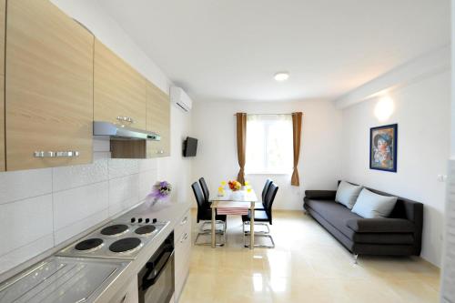 cocina y sala de estar con sofá y mesa en Villa Katarina, en Kaštela