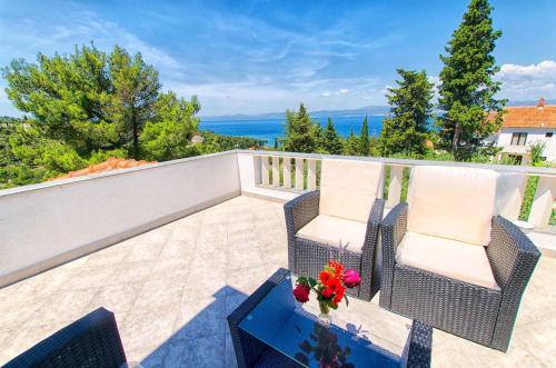 a balcony with two chairs and a table with flowers on it at Apartments Damir - Katarina in Sutivan