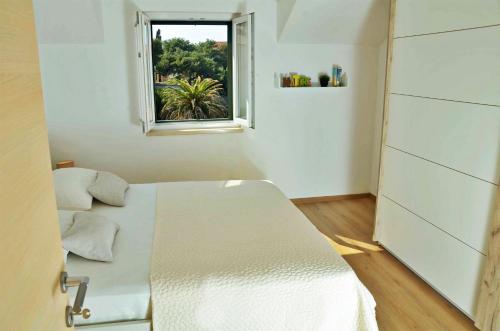 um pequeno quarto com uma cama e uma janela em Apartment Luna em Postira