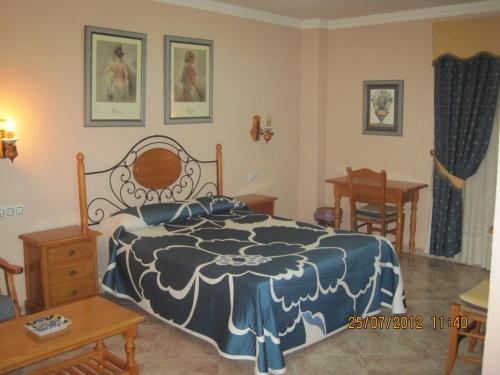1 dormitorio con 1 cama, mesa y sillas en Hotel Caballo Negro, en Puerto Real